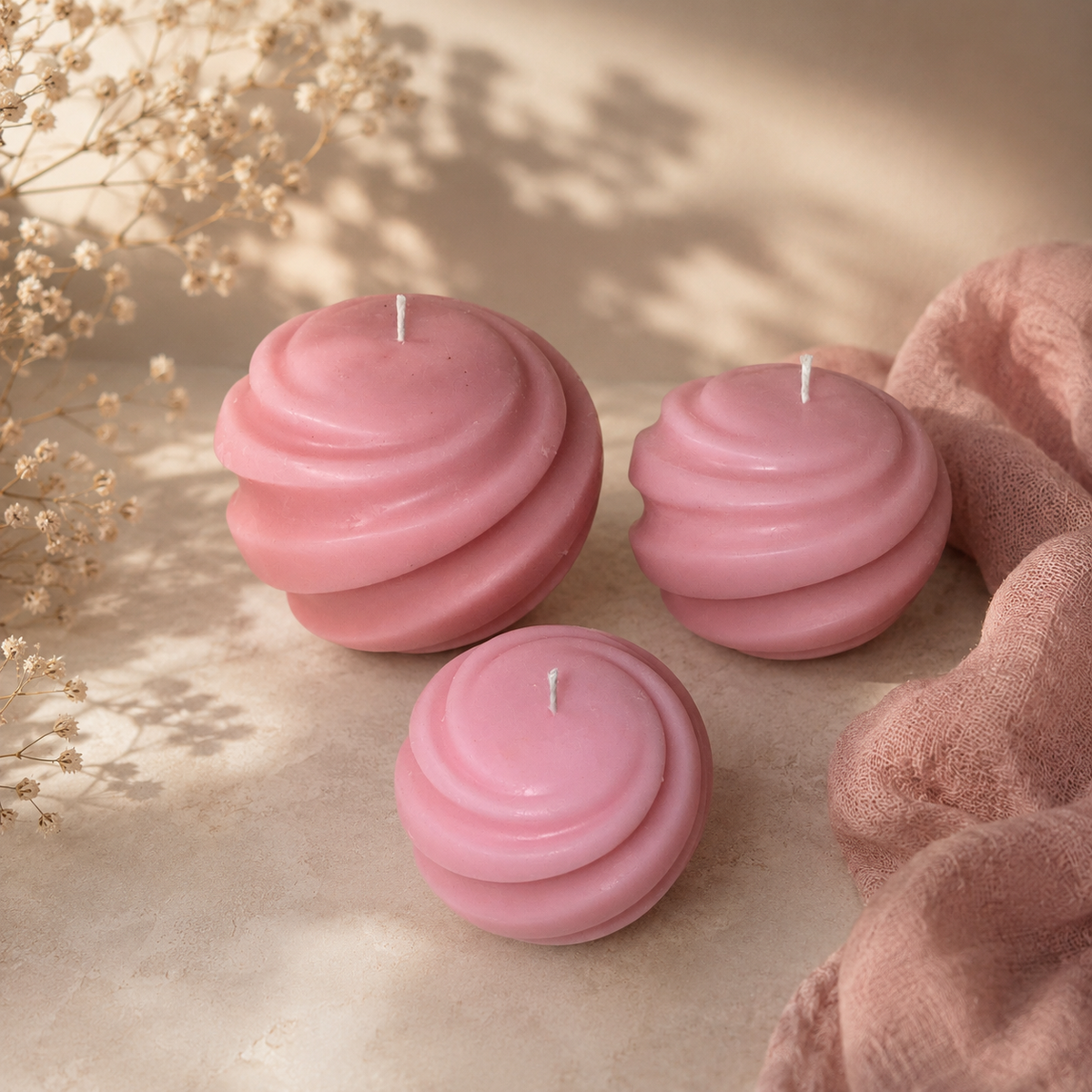 Sage green spiral sphere candle styled on a neutral surface